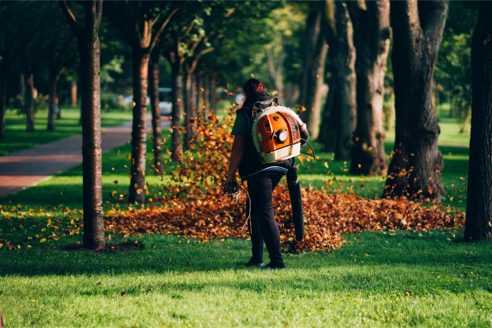 Worker using a heavy duty leaf blower for yard cleanup